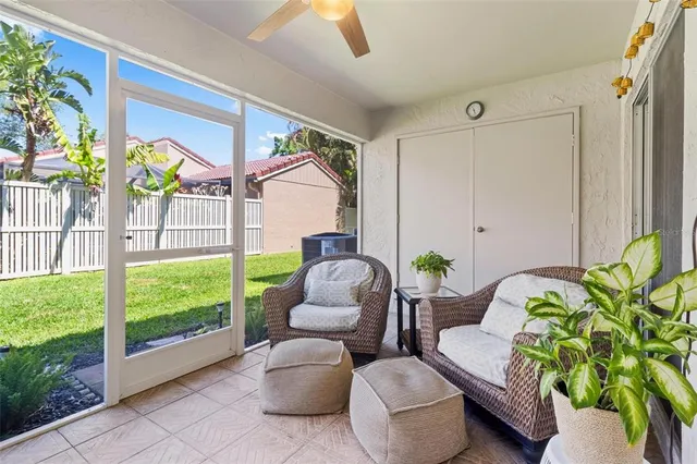 a living room with patio furniture and a potted plant