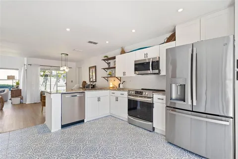 a kitchen with granite countertop stainless steel appliances and refrigerator