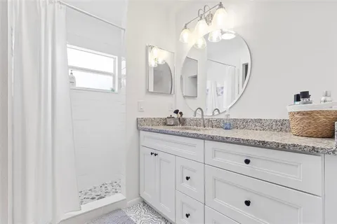 a bathroom with a granite countertop sink mirror and