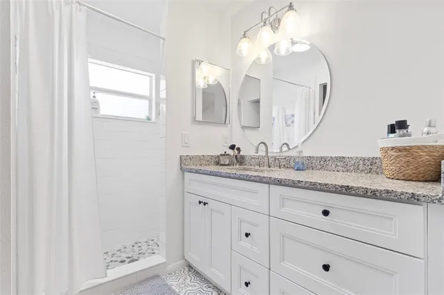 a bathroom with a granite countertop sink mirror and