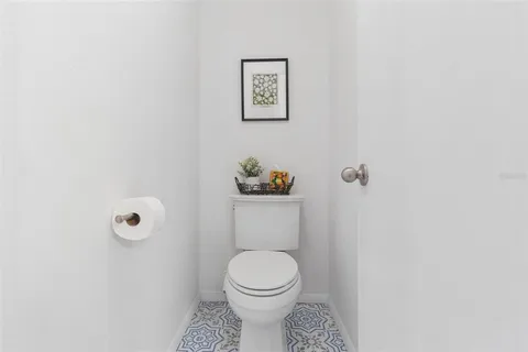 a white toilet sitting next to a white wall