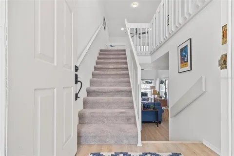 a view of staircase with lots of frames on wall and windows