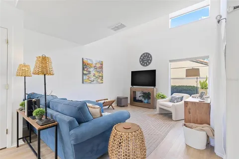 a living room with furniture a flat screen tv and a large window