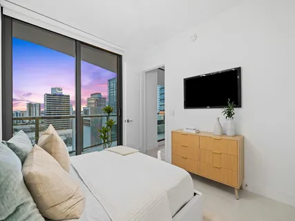 a bedroom with a bed and a flat screen tv
