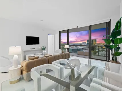 a living room with furniture a flat screen tv and a floor to ceiling window
