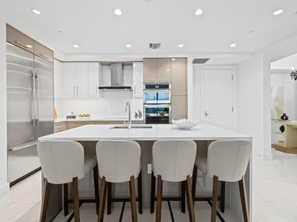 a kitchen with a dining table chairs and refrigerator