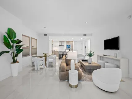 a living room with furniture a flat screen tv and a potted plant