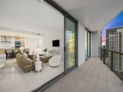 a living room with furniture a flat screen tv and a large window