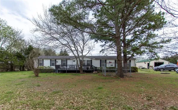 a front view of a house with a yard and trees