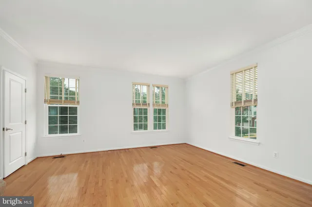 a view of a kitchen with kitchen island a sink wooden floor and a large window