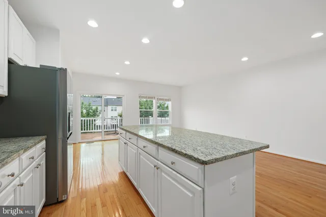 a kitchen with granite countertop a refrigerator and a sink