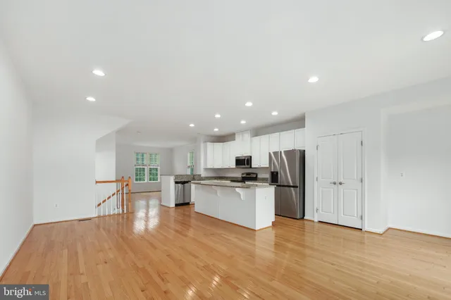 a kitchen with stainless steel appliances granite countertop a stove top oven a sink and a granite counter tops with wooden floors