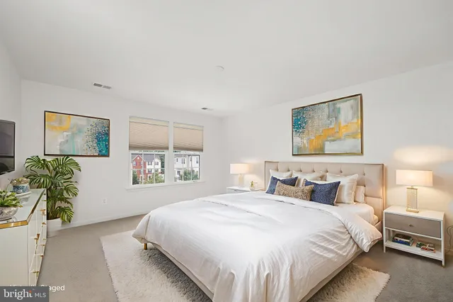 a bedroom with a bed and a painting on the wall