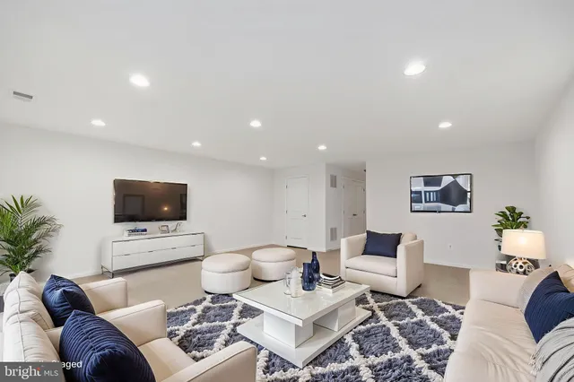 a living room with furniture a flat screen tv and a window