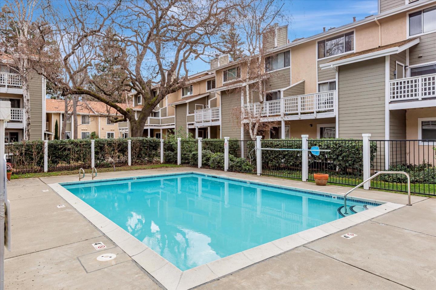 2575 Oak Road, Unit B Walnut Creek, CA 94597 - Photo 17 of 20 a view of a building with a swimming pool and a large tree