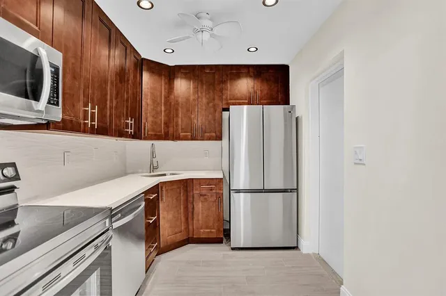 a kitchen with stainless steel appliances a refrigerator and a microwave