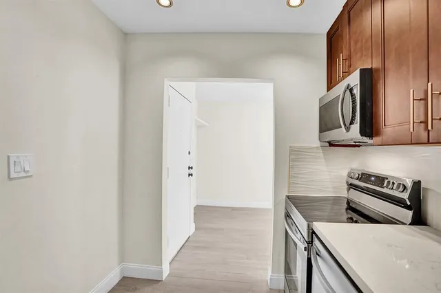 a kitchen with stainless steel appliances a refrigerator and a stove top oven