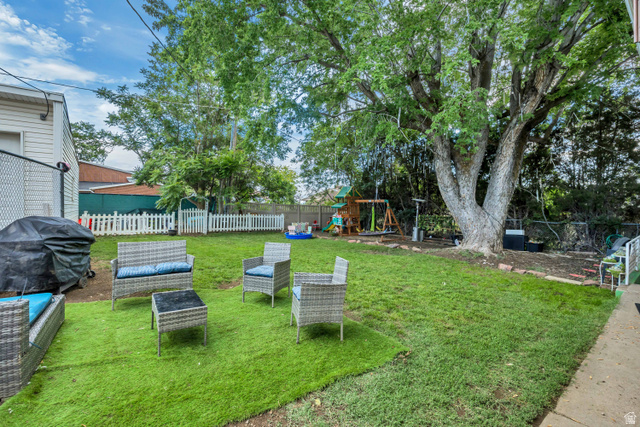 1215 8th Street Ogden, UT 84404 - Photo 36 of 39 Expansive backyard featuring a large tree, green lawn, white picket fence, and a patio area with artificial turf