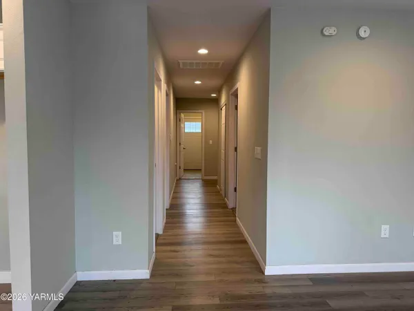 a view of a hallway with wooden floor