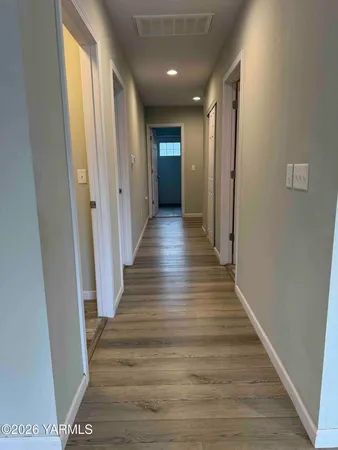 a view of a hallway with wooden floor