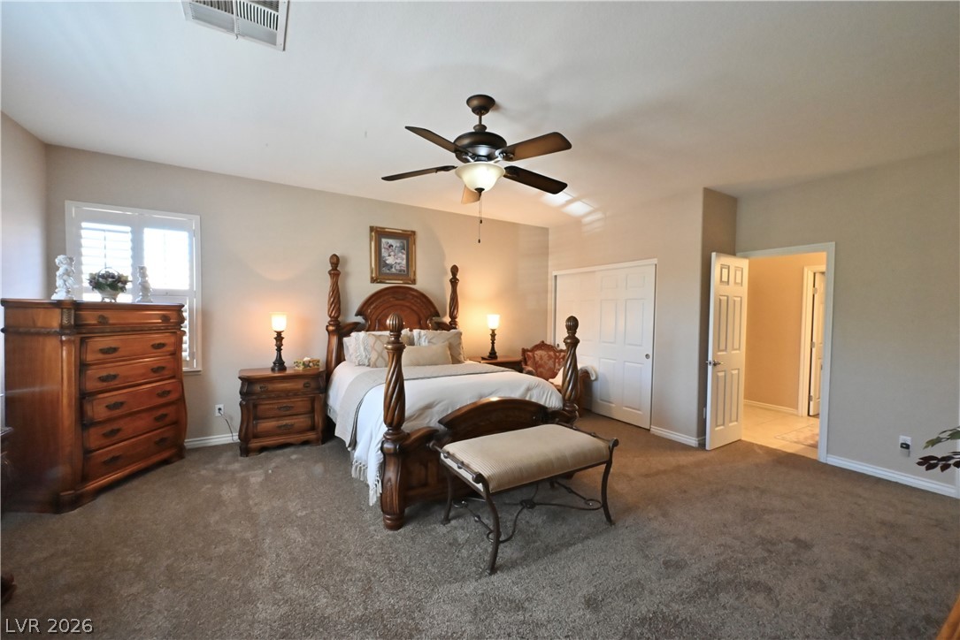 2729 Kildrummie Street Henderson, NV 89044 - Photo 29 of 42 A restful primary bedroom featuring plush carpet and a stylish ceiling fan for comfort.