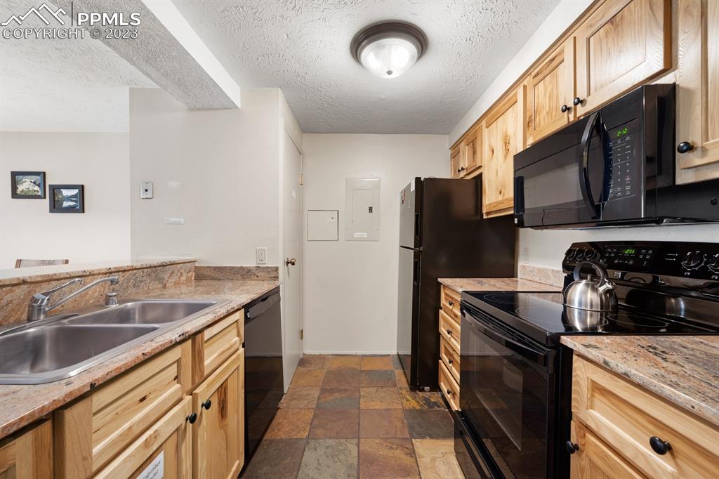 651 Gothic Road, Unit 301 Crested Butte, CO 81225 - Photo 11 of 24 a kitchen that has a sink wooden cabinets and stainless steel appliances