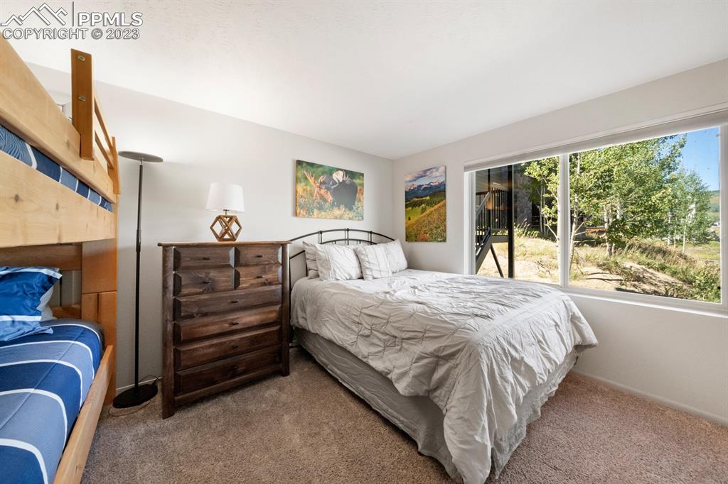 651 Gothic Road, Unit 301 Crested Butte, CO 81225 - Photo 22 of 24 a bedroom with a bed and large windows