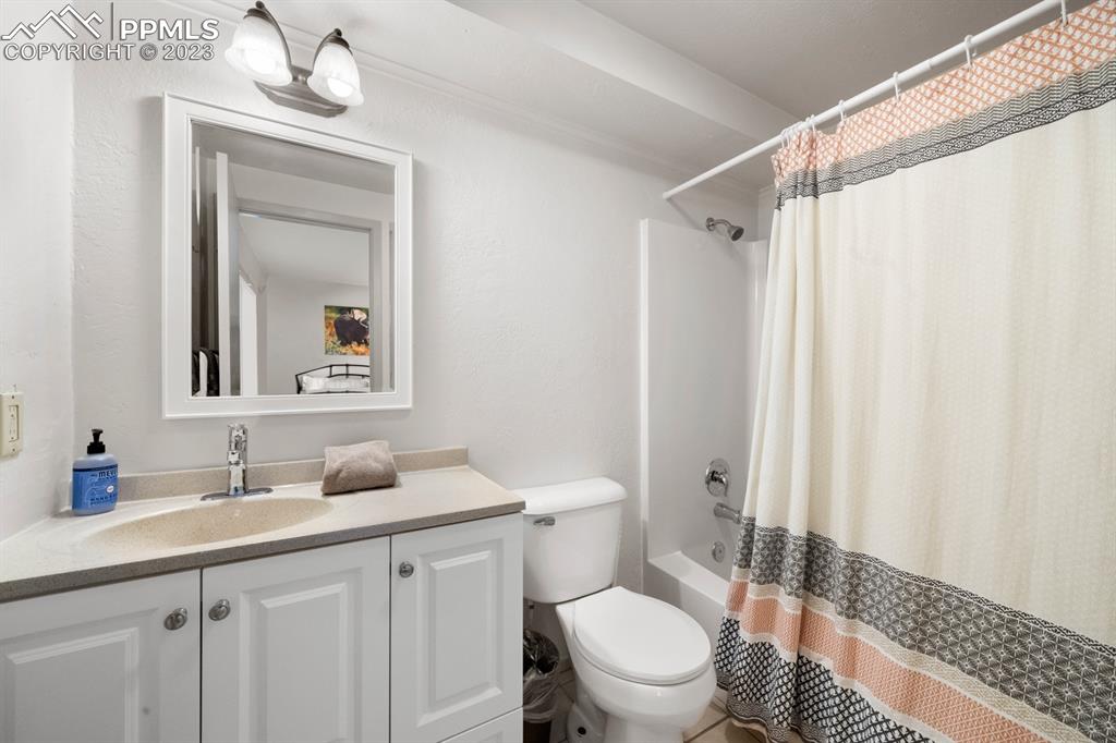 651 Gothic Road, Unit 301 Crested Butte, CO 81225 - Photo 23 of 24 a bathroom with a granite countertop sink toilet and shower