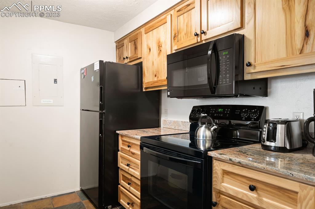 651 Gothic Road, Unit 301 Crested Butte, CO 81225 - Photo 10 of 24 a kitchen with stainless steel appliances granite countertop a refrigerator stove and microwave