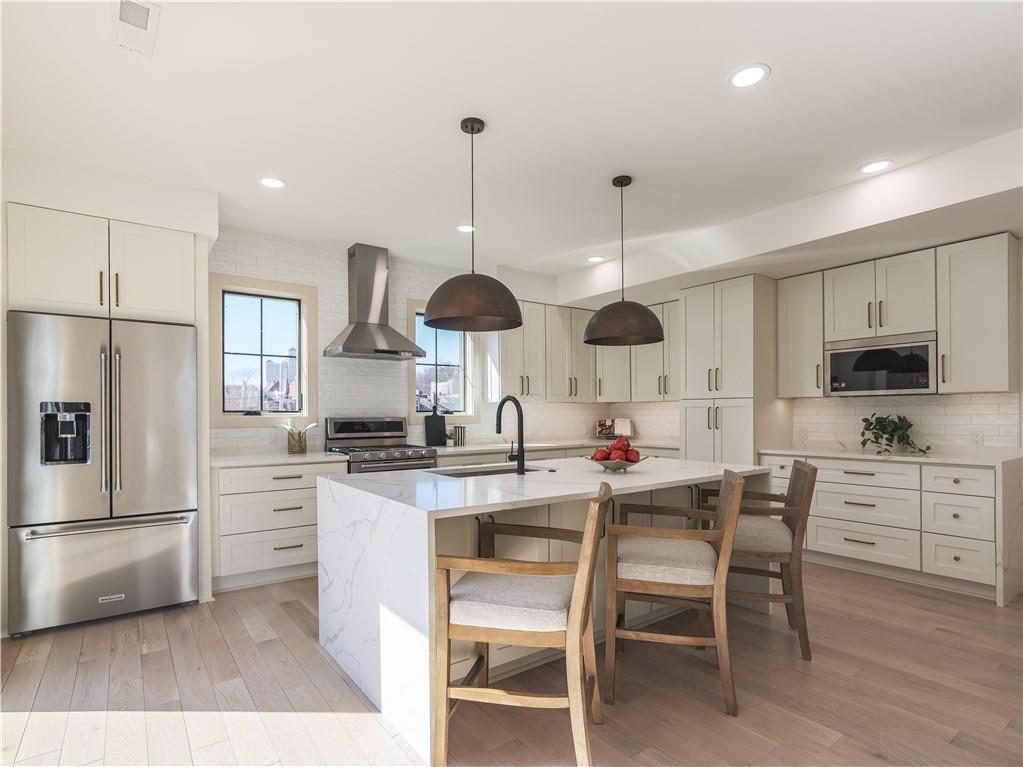 909 Rickenbach Street Pittsburgh, PA 15212 - Photo 5 of 23 a kitchen with stainless steel appliances a dining table chairs stove and refrigerator