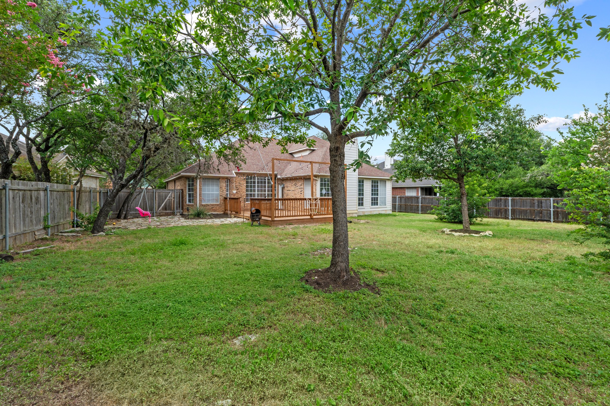 8605 Axis Drive Austin, TX 78749 - Photo 36 of 38 A spacious backyard with mature trees and a charming deck, perfect for outdoor enjoyment.