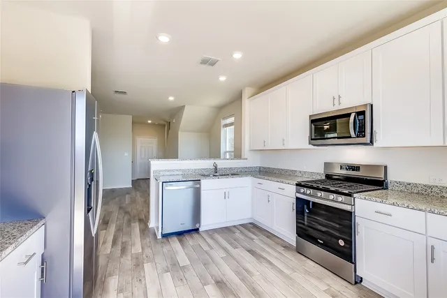 a kitchen with granite countertop a stove top oven and sink