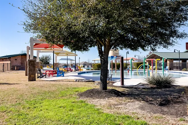 a view of a swimming pool with a lawn chairs under an umbrella