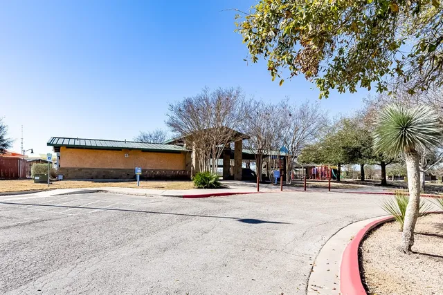 a view of a swimming pool with a lawn chairs under an umbrella