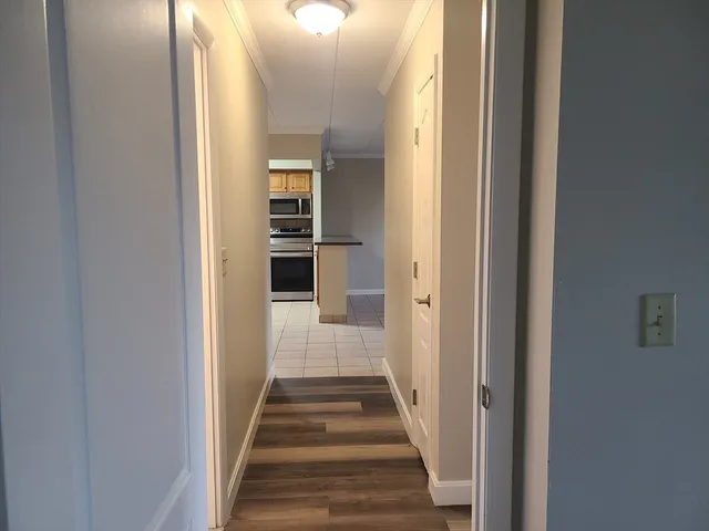 a view of a hallway with wooden floor and entryway