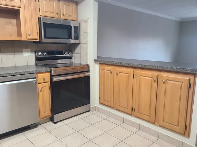 a kitchen with granite countertop white cabinets and stainless steel appliances