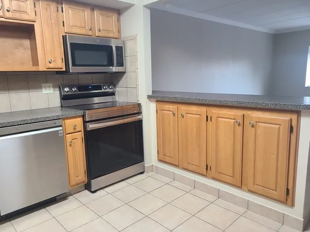 a kitchen with granite countertop white cabinets and stainless steel appliances