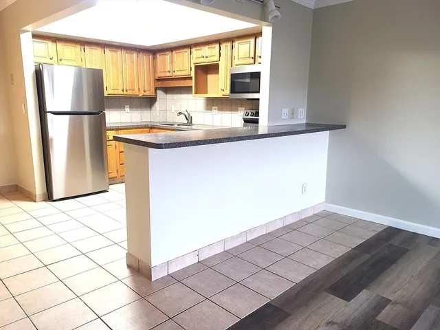 a kitchen with a sink a refrigerator and a window