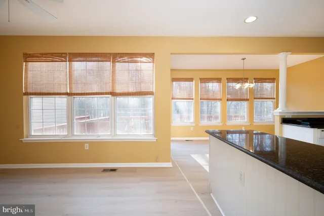 a view of a hallway with wooden floor and a living room
