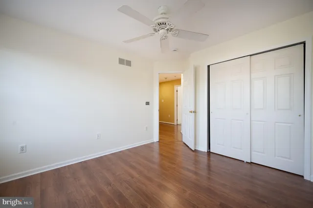 an empty room with a window and a chandelier fan