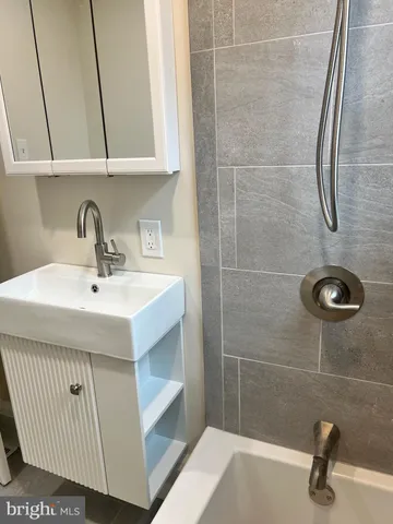 a bathroom with a sink a mirror and shower