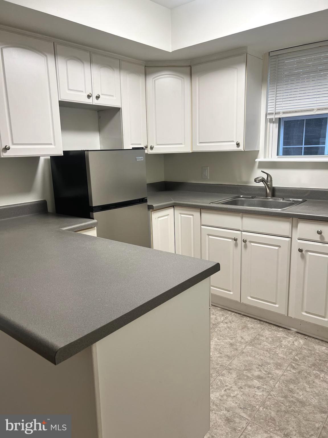 362 Ripka Street, Unit A Philadelphia, PA 19128 - Photo 5 of 18 a kitchen with granite countertop a sink a stove and cabinets