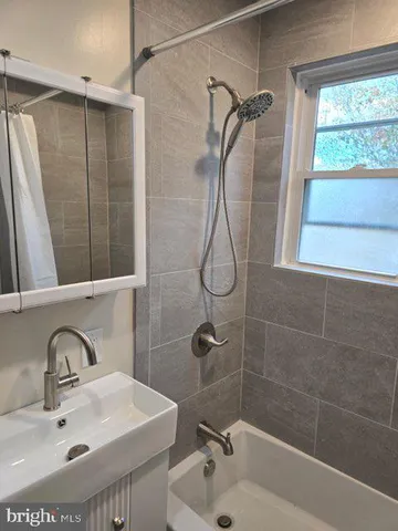 a bathroom with a sink mirror and shower