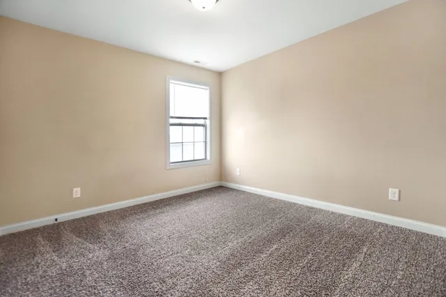an empty room with a window and a ceiling fan