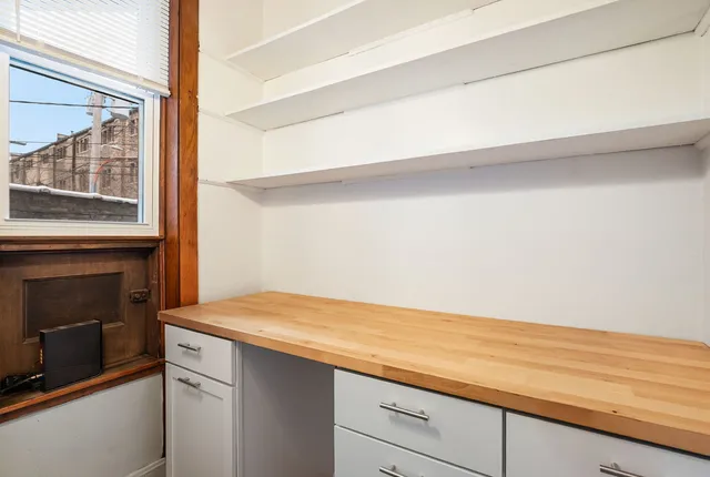 a view of kitchen and empty room with wooden floor