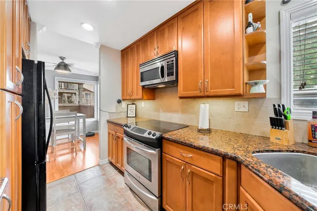 a kitchen with stainless steel appliances granite countertop a refrigerator stove and sink