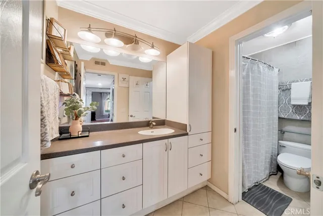 a spacious bathroom with a granite countertop sink a toilet and a mirror