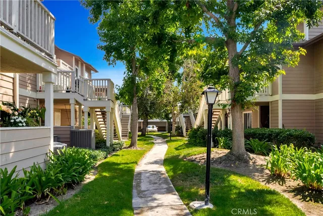 a view of a patio with couches plants and large tree