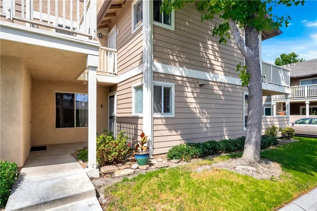 a view of a house with potted plants and a table and chairs