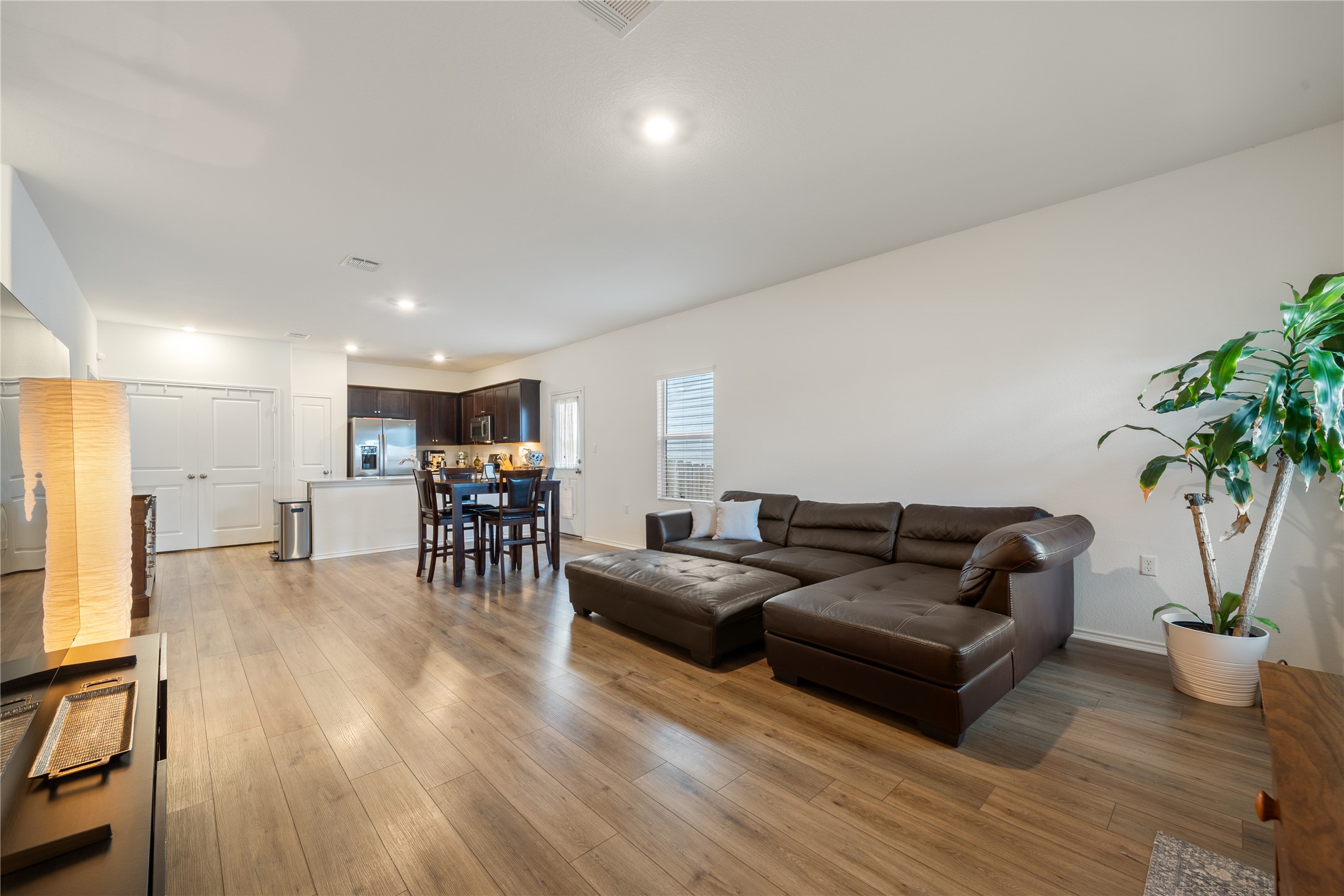 14404 Berning Road Manor, TX 78653 - Photo 5 of 38 An open concept living area features resilient wood-look flooring, seamlessly connecting to the modern kitchen.